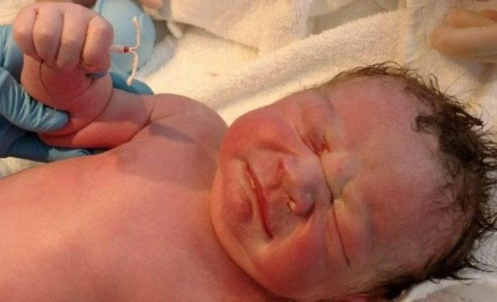 Доктор принёс мамочке только что родившегося младенца. Взгляни, что новорождённый держит в правой руке?